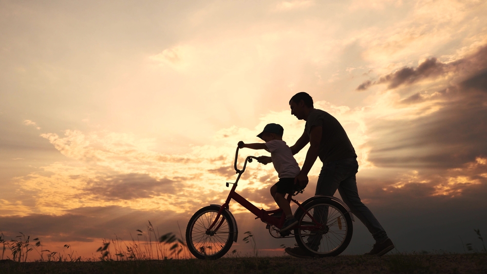 父親が息子に自転車にのるコツを教えている