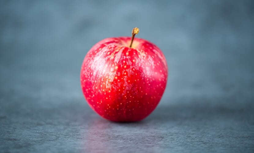 One,Red,Apple,On,Dark,Gray,Background.